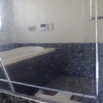 水垢の堆積した浴室鏡を研磨して再生する技術を講習する磨学校
